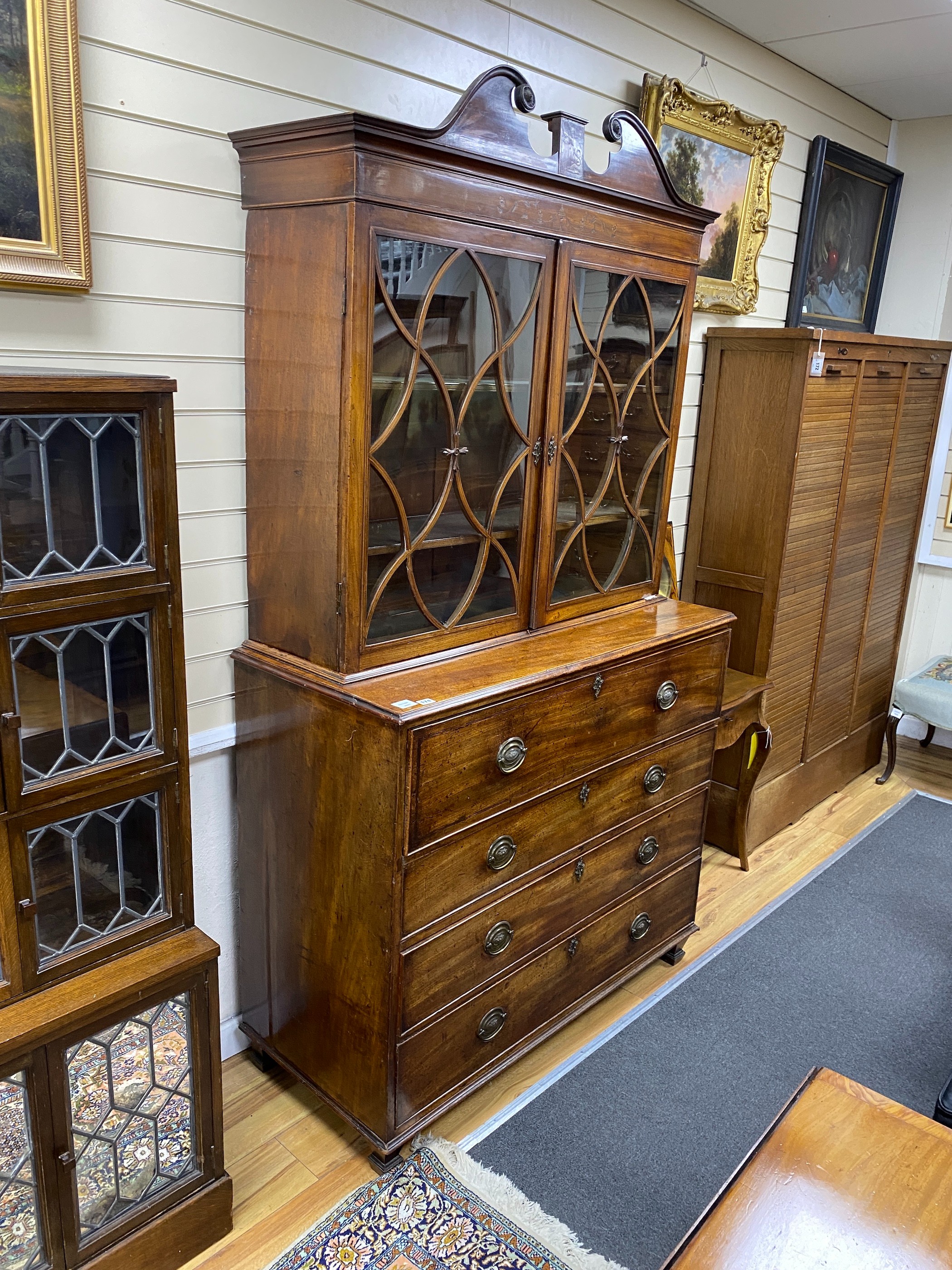 A Regency mahogany secretaire bookcase, fitted over with an earlier two door glazed cabinet, width 121cm, depth 52cm, height 214cm